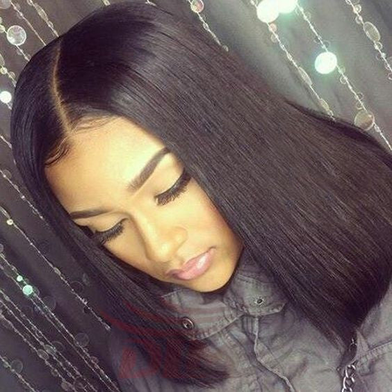 A woman with straight, shoulder-length black hair and a defined side hair parting looks down with her eyes closed.