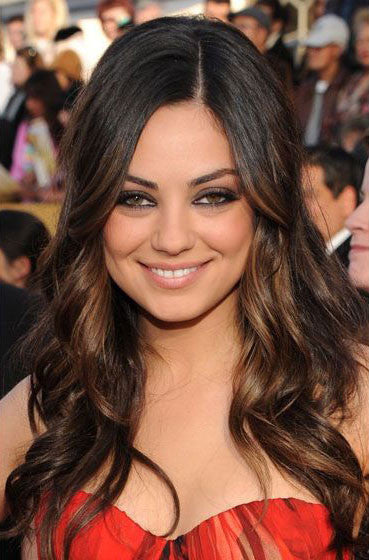 A woman with long, wavy dark brown Virgin Remy hair and highlighted strands is smiling.