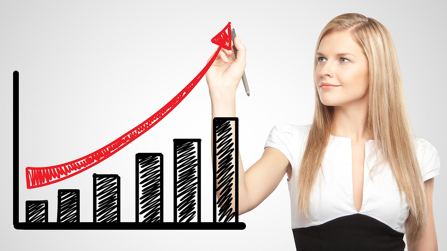 A Marketing Manager in business attire smiles as she draws a red upward arrow over a bar graph on a transparent screen, symbolizing Growth Marketing success.