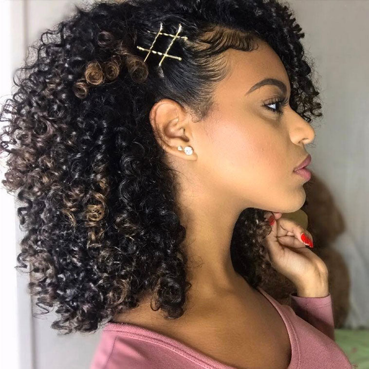 Curly Girl with medium-length, curly hair styled with gold bobby pins on the side, wearing stud earrings and a pink top, shown in profile against a neutral background, a perfect look for your New Year style inspiration.