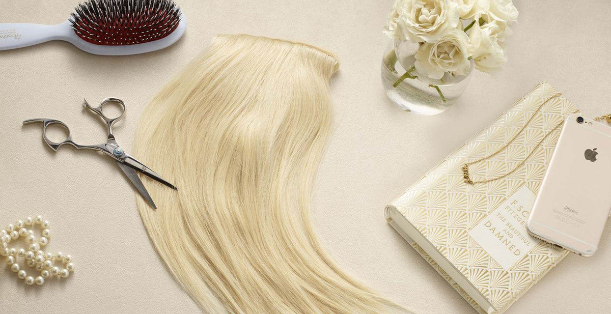 Perfect Locks blonde hair extensions displayed with styling scissors and accessories on a light surface