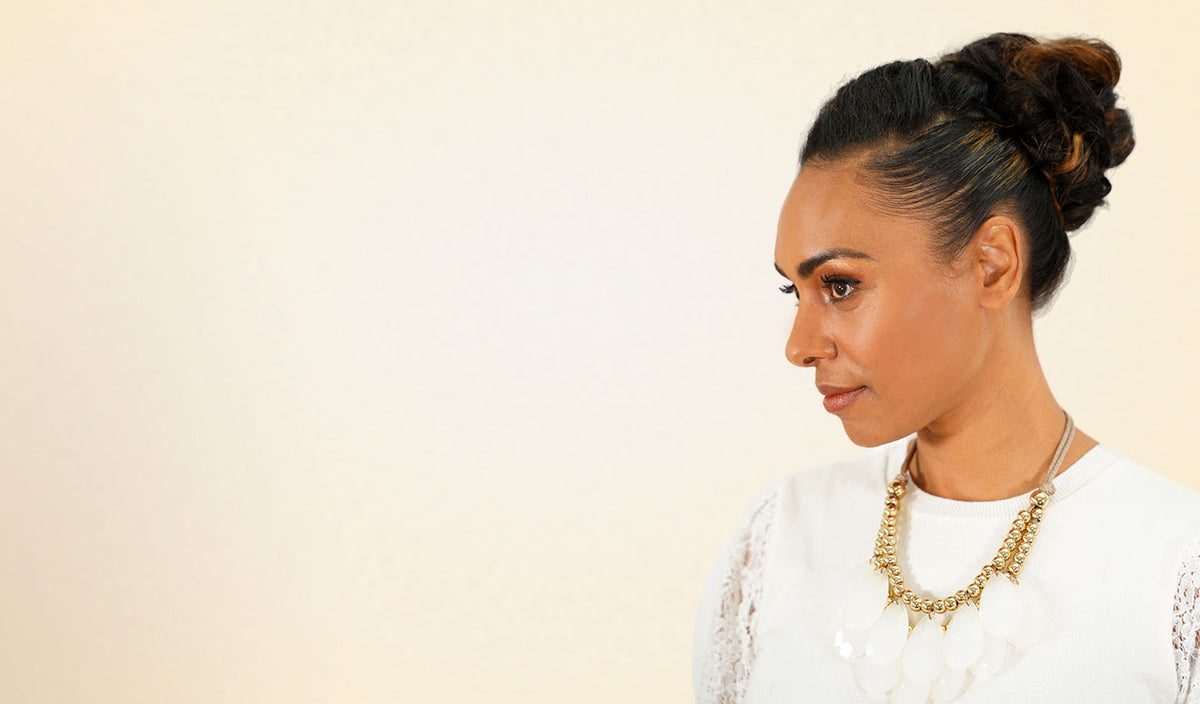 Woman with an elegant braided updo using Perfect Locks human hair scrunchies and a gold necklace