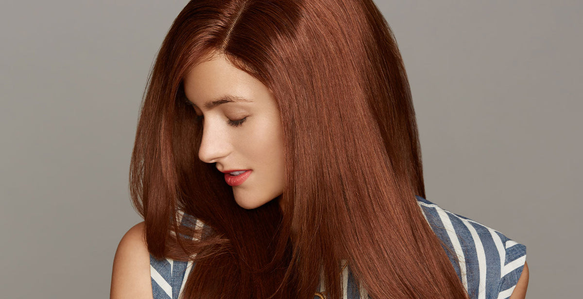 Woman with long, straight auburn Perfect Locks straight clip-in extensions and a natural smile