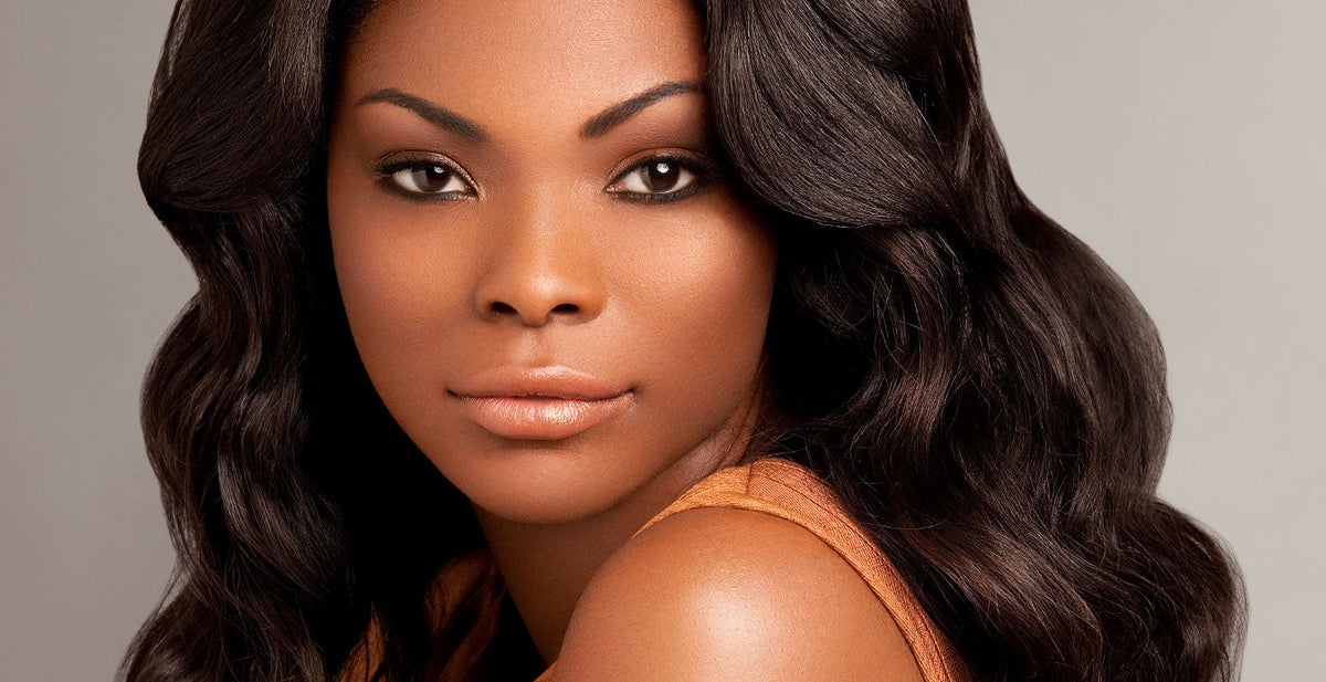Woman wearing a Perfect Locks wavy lace front wig with long dark waves and natural makeup