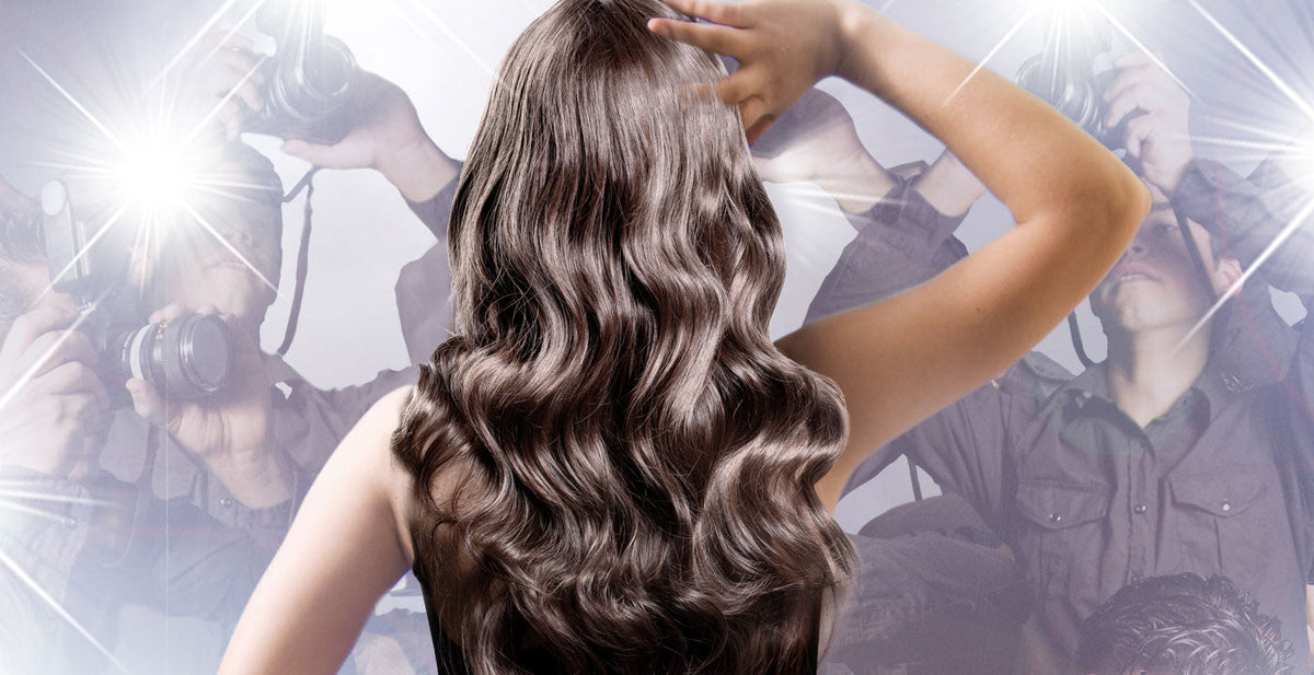 Woman wearing a Perfect Locks celebrity style wig with long, wavy brown hair on the red carpet