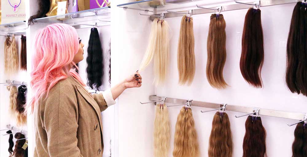Perfect Locks hair extensions displayed by texture in a range of colorful styles at the showroom