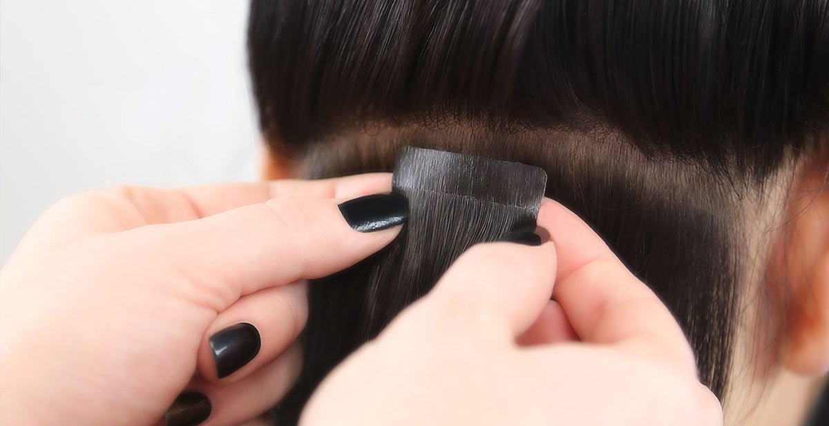 Hands applying Perfect Locks replacement tape for tape-ins to attach a hair extension at the roots