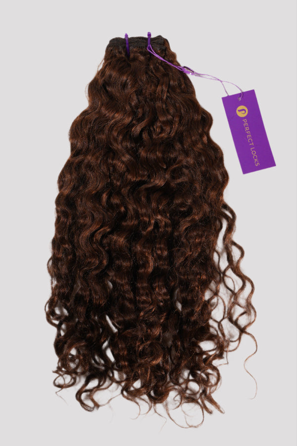 A bundle of dark brown, curly hair extensions labeled Perfect Locks with a purple tag at the top against a light gray background.