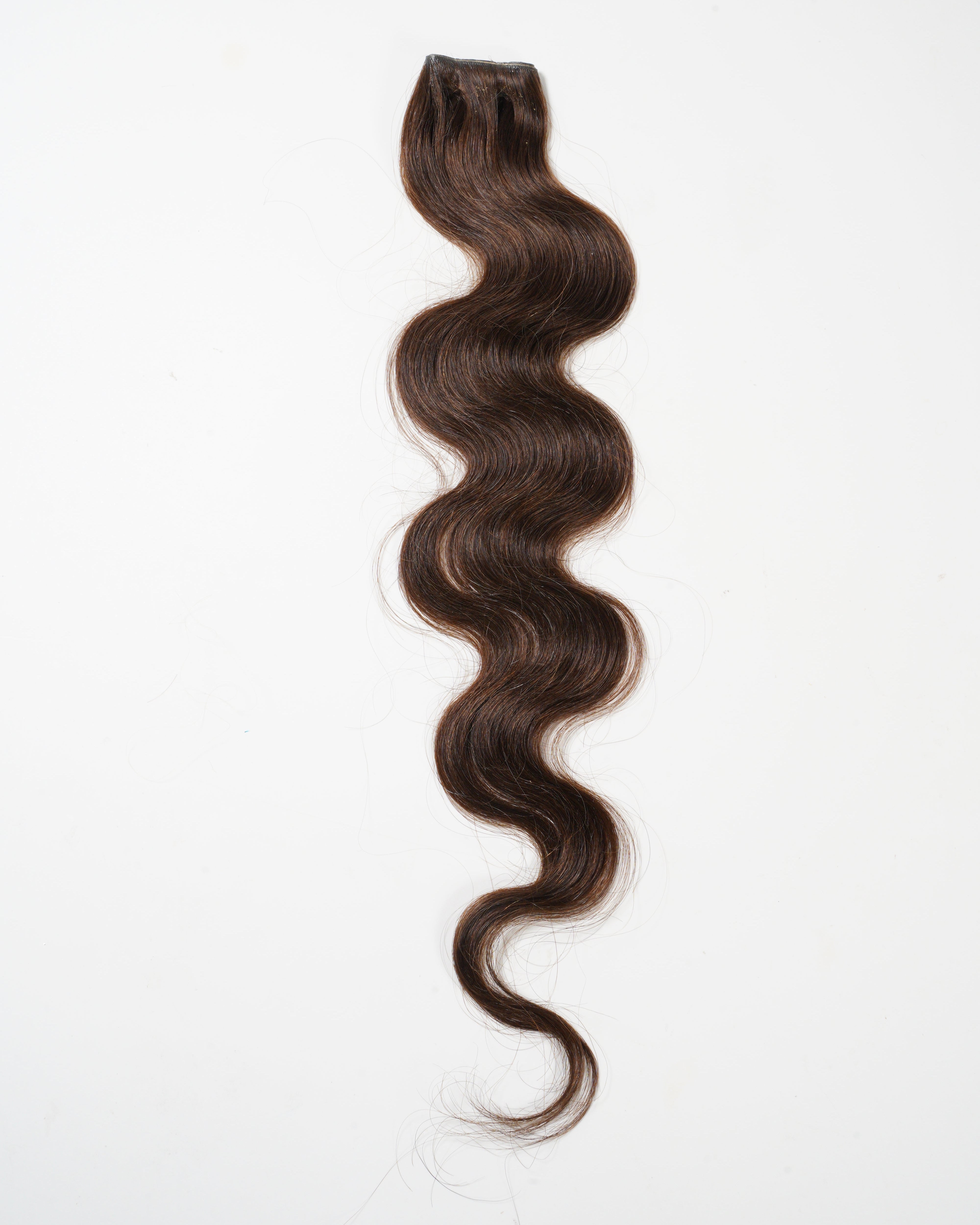 A single bundle of long, dark brown, wavy virgin hair extension is displayed on a white background.