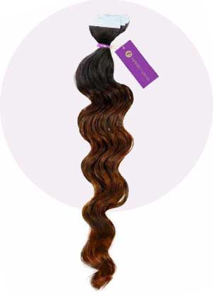 A bundle of wavy, ombre hair extensions transitions from dark brown at the top to lighter brown ends, secured with a purple band and an elegant tag.