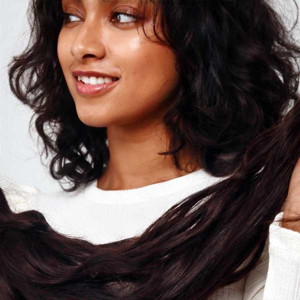 Woman holding a bundle of human hair extensions