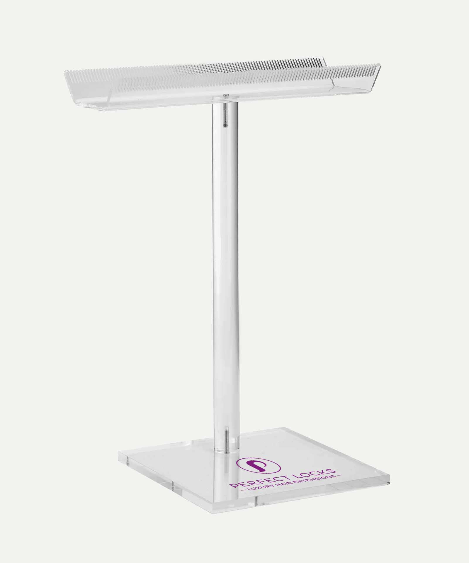 A clear acrylic stand with square base and vertical pole holds a tray with fine comb-like teeth. Purple Perfect Locks logo on base.