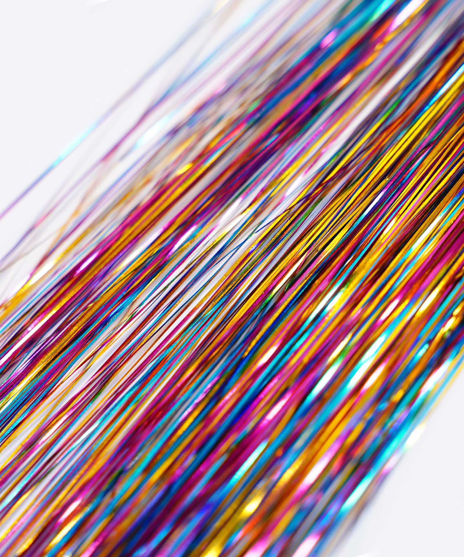 Close-up of Perfect Hair Tinsel by Perfect Locks in Gold Glitz mingled with hair extensions; shiny threads add vibrant sparkle.#color_night-out