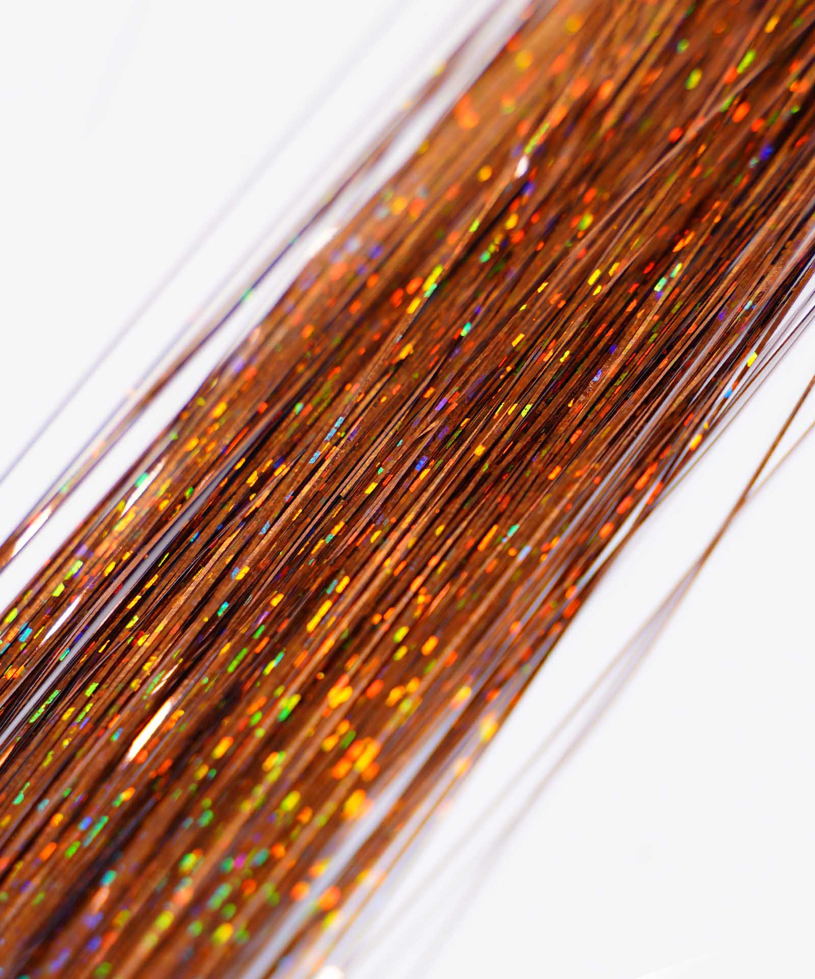 Close-up of Perfect Locks' Perfect Hair Tinsel in Unicorn color, with shiny, multicolored strands creating a sparkling, festive look against a white background.#color_rust