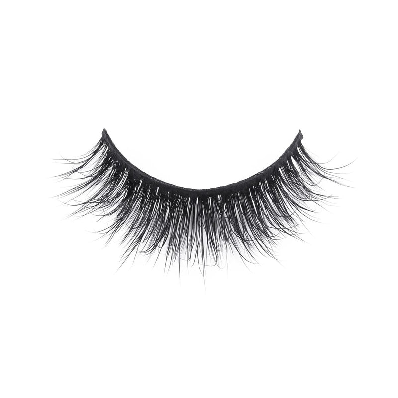 A single strip of black false eyelashes with mink-like, long, wispy, voluminous fibers arranged in a natural curve on white.