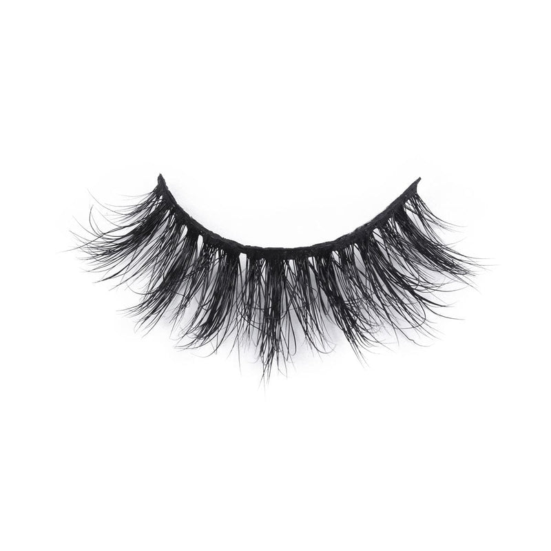 A single false eyelash strip with thick, voluminous black lashes is curved dramatically against a white background.
