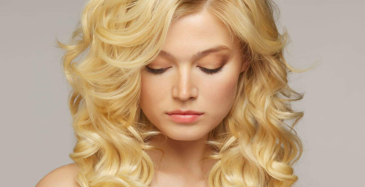 Woman with voluminous wavy blonde Perfect Locks curly hair weave styled in an elegant look