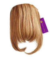 A honey blonde Clip-In Bangs hair extension by Perfect Locks with straight, curved ends and a purple branded tag attached.#color_honey-blonde-(27)