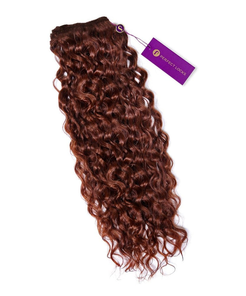 A bundle of long, dark auburn Curly Colored Hair Machine Weft extensions with shiny curls and a purple Perfect Locks tag on top.