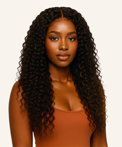 Woman with long, curly hair wearing a brown top on a white background