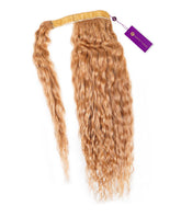 A single Curly Clip-In Ponytail Extension by Perfect Locks in Honey Blonde with a yellow band, purple tag, and soft waves.#color_honey-blonde-(27)