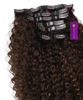 Curly Seamless Clip-In Hair Extensions by Perfect Locks in rooted mocha bronde highlights, stacked with clips and purple tags, showing glossy Remy hair.#color_rooted-mocha-bronde-highlights-(2/6/2)