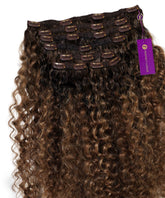 Perfect Locks Curly Seamless Clip-In Hair Extensions with tight curls, toffee blonde highlights, black clips, and purple tag.#color_rooted-toffee-blonde-highlights-(4/27/4)