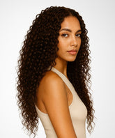A woman wears the Perfect Locks Curly U-Part Wig in Natural Black  and a beige sleeveless top, looking over her shoulder at the camera against a white background with a neutral expression.#color_chocolate-brown-(3)