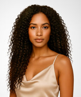 Woman with long, curly hair wearing a beige satin top against a white background#color_natural-black-(1B)