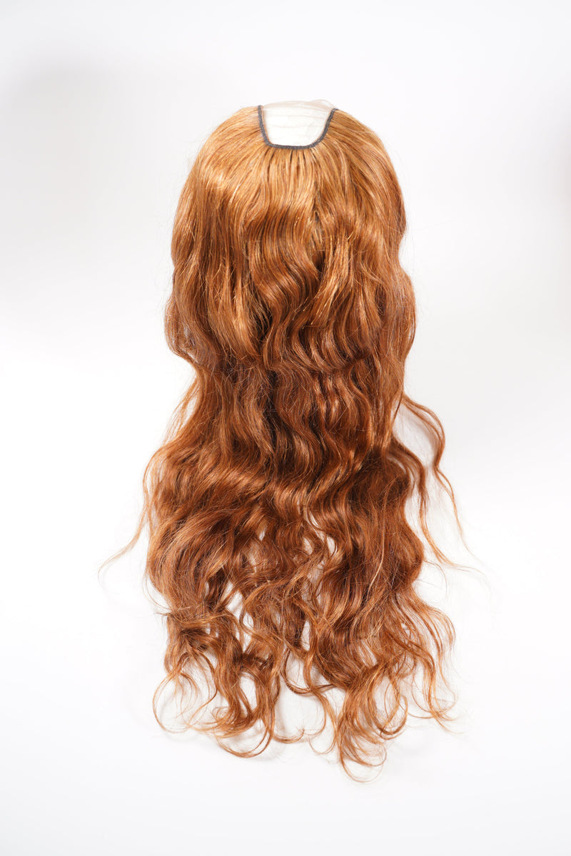 A long, wavy, reddish-brown hair topper with a center part showcased against a white background, adding volume and style.
