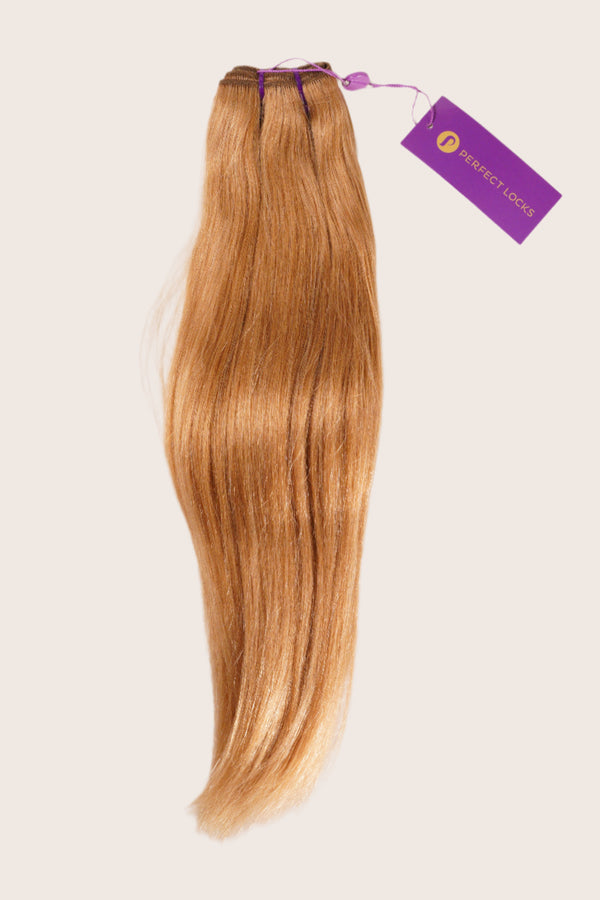 A bundle of straight, light brown hair extensions with a purple Perfect Locks tag is neatly arranged on a light background.