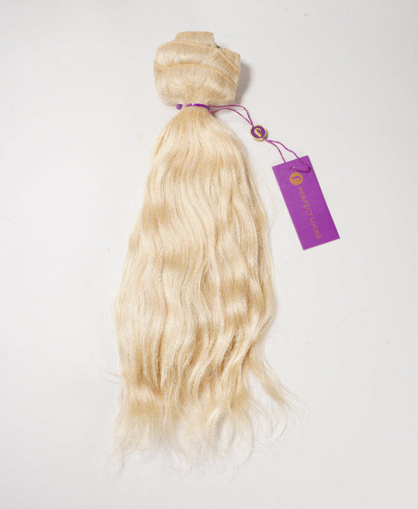 A bundle of long, wavy, platinum blonde hair extensions tied with a purple string and tag on a white background.