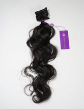 Black hair extensions with a purple tag on a white background