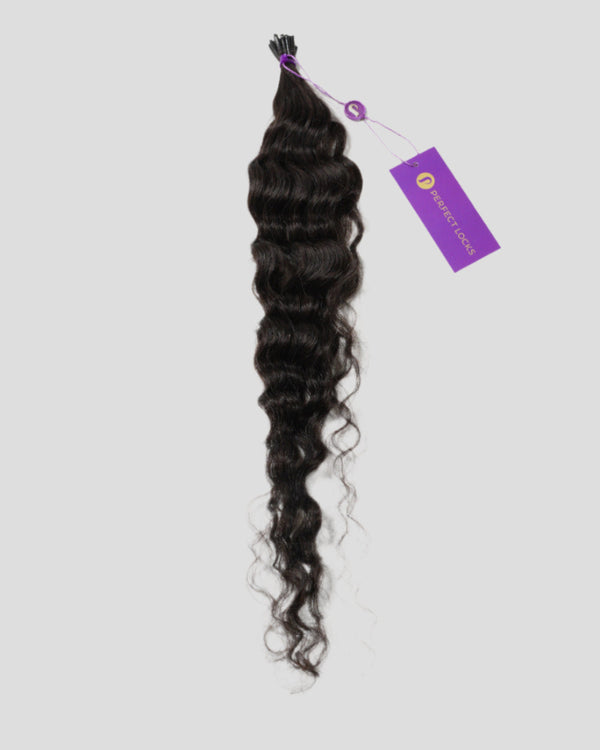 A bundle of long, wavy, dark brown hair extensions tied at the top with a purple tag, showcased against a plain light gray background.