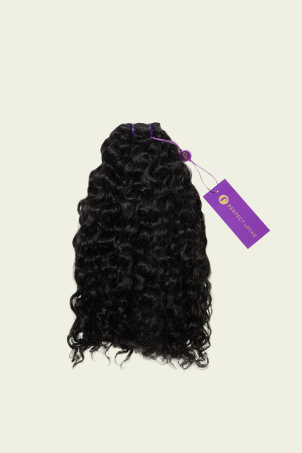 A bundle of curly black hair extensions with a purple PERFECT LOCKS tag is showcased against a plain light background.