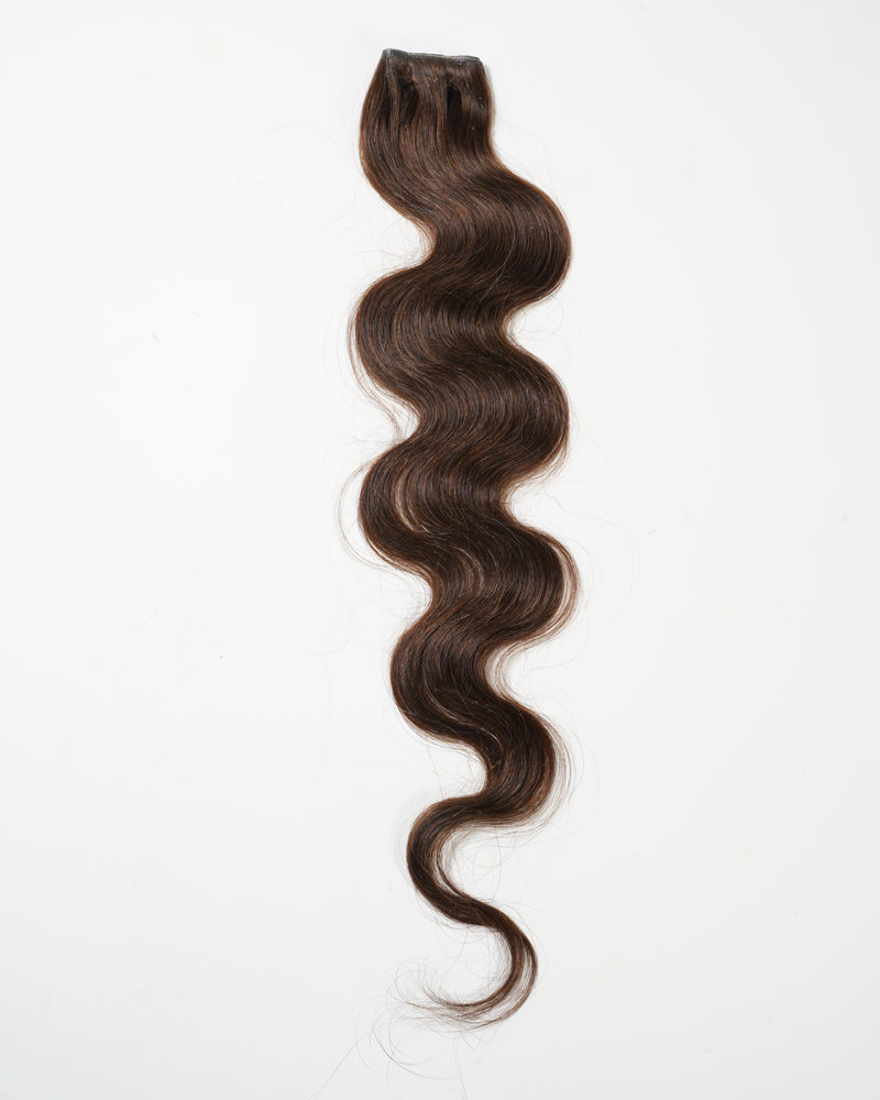 A single bundle of long, dark brown, wavy virgin hair extension is displayed on a white background.