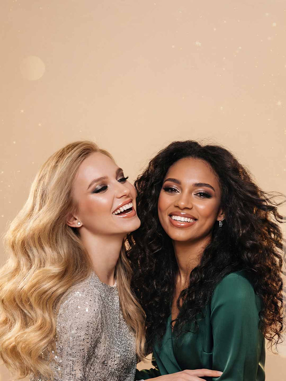 Two women posing together against a beige background