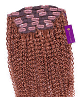 The Kinky Curly Classic Clip In Hair Extensions by Perfect Locks have tight, golden brown Remy curls, pink clips, and a purple tag.#color_golden-brown-(6)