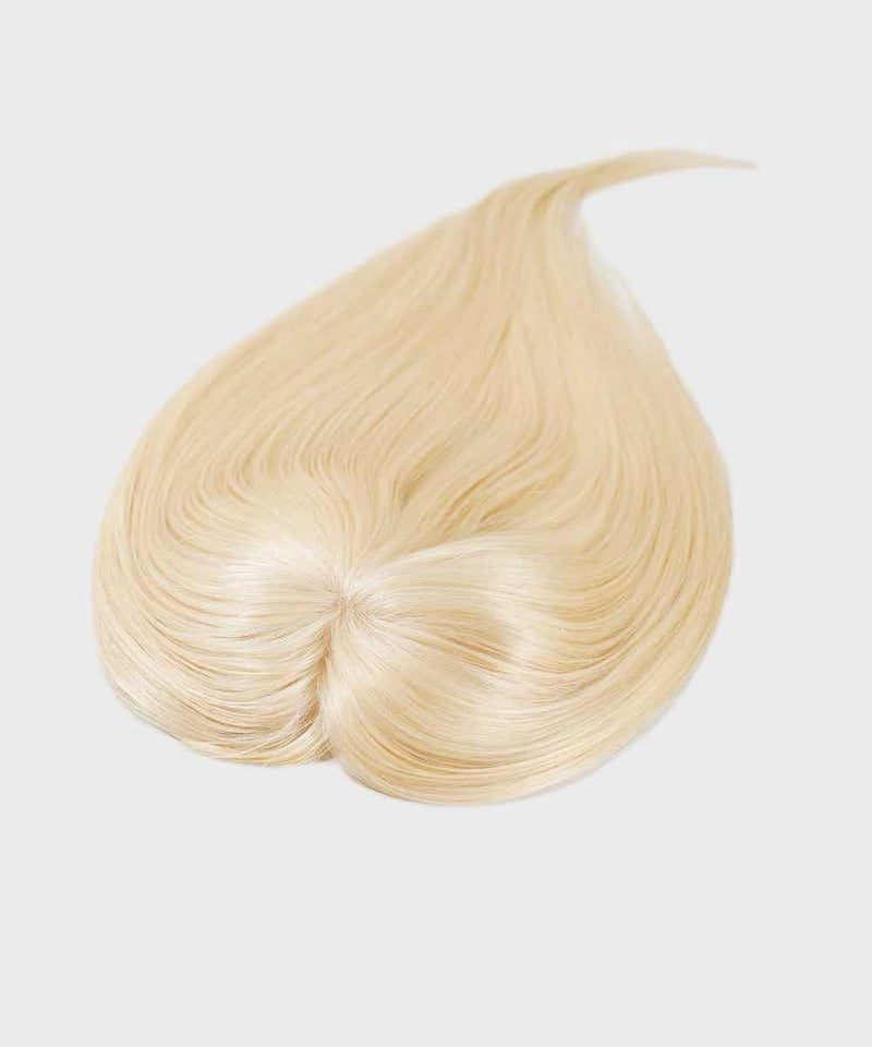 A Straight Human Hair Crown Topper by Perfect Locks in ash blonde is arranged on a white background, with tapered ends and a subtle swirl at the base.