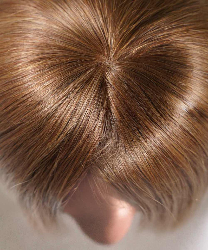 Close-up of the crown of a head with golden brown hair, natural parting, healthy shine; face not shown. Ideal for hair topper.