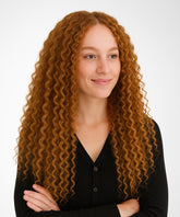 A woman wears the Perfect Locks Tight Curly U-Part Wig in Golden Brown, black buttoned shirt, arms crossed, smiling softly.#color_golden-brown-(6)