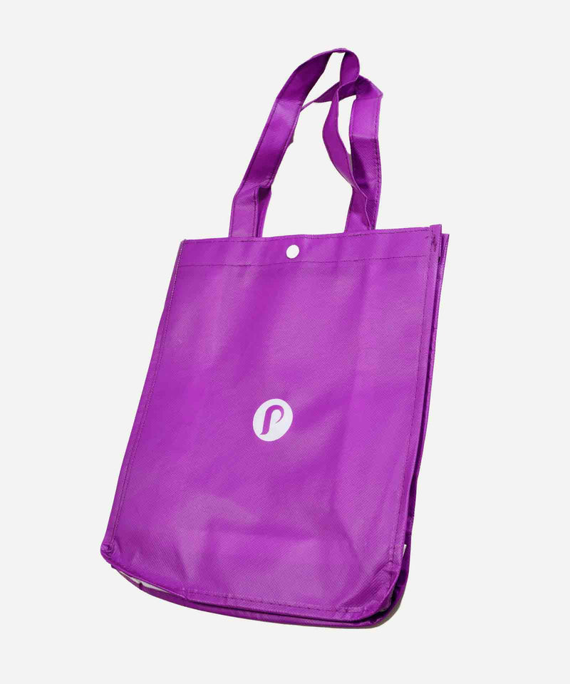 The Perfect Locks Tote Bag (Retail) is a purple reusable bag with two handles and a small white circular logo, ideal for carrying hair extensions or essentials, against a white background.