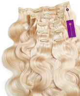Wavy Seamless Clip-In Hair Extensions in ash blonde fanned out, showing beige clips and a purple Perfect Locks tag attached.#color_ash-blonde-(60)
