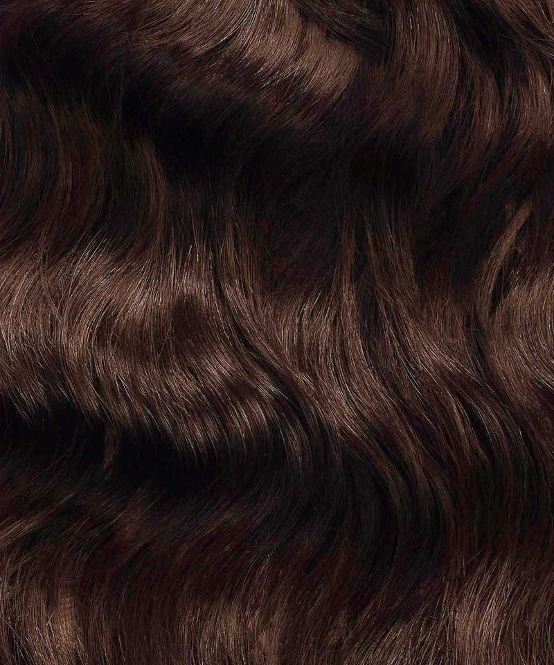 Close-up of Perfect Locks Wavy Fusion I-Tip Hair in Chocolate Brown, shiny Remy extensions with wavy texture and subtle highlights.