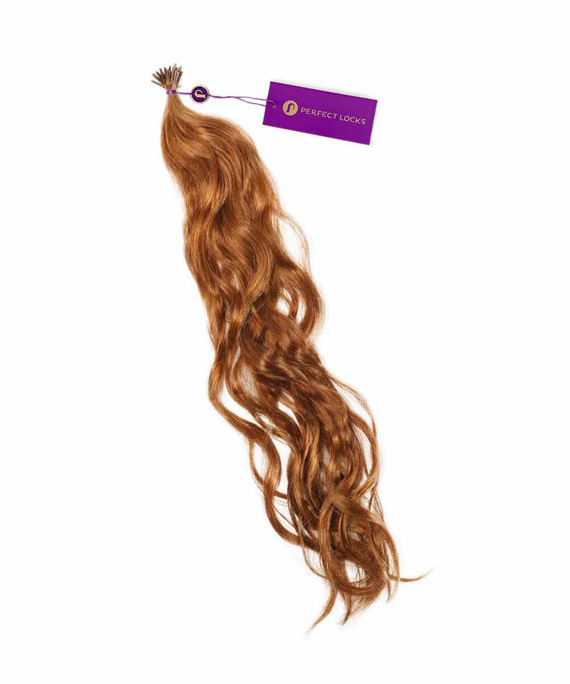 A bundle of long, wavy Golden Brown  Perfect Locks Wavy Fusion I-Tip Hair extensions, shiny and healthy, with a small purple tag near the top.