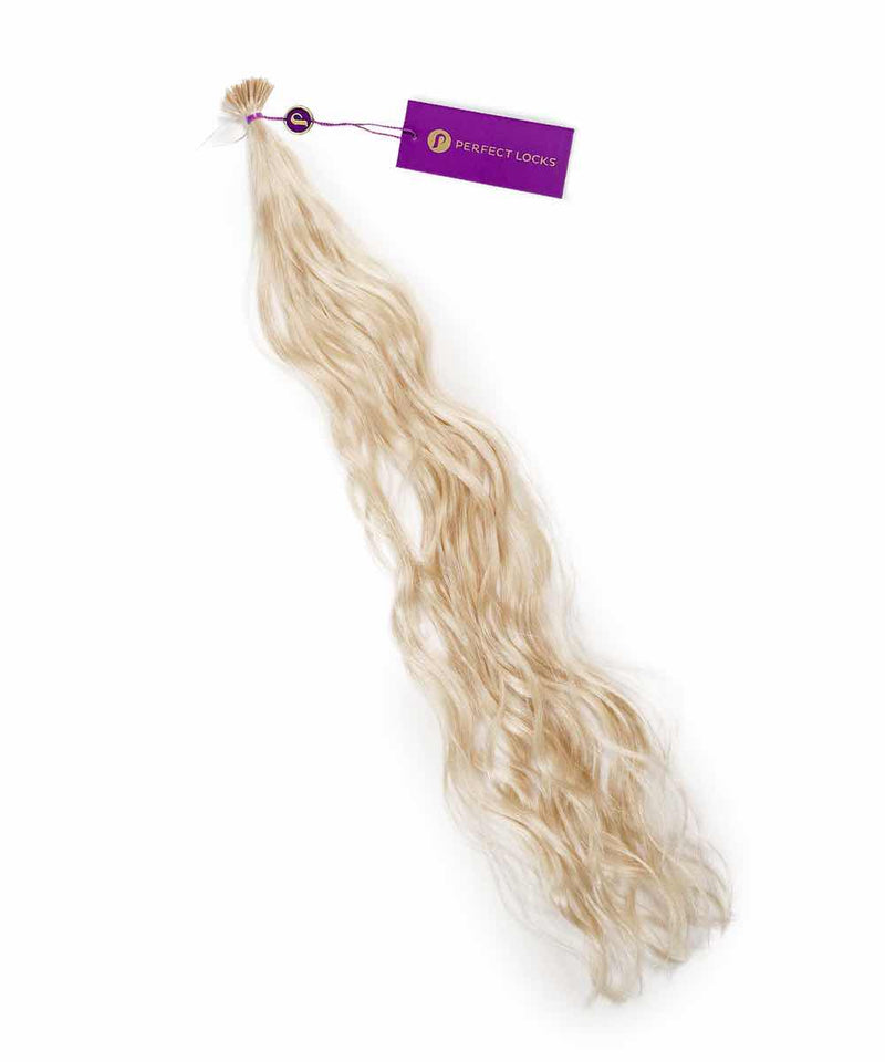 A bundle of long, wavy ice blonde Perfect Locks Wavy Fusion I-Tip Hair extensions tied at the top with a purple tag labeled Perfect Locks.