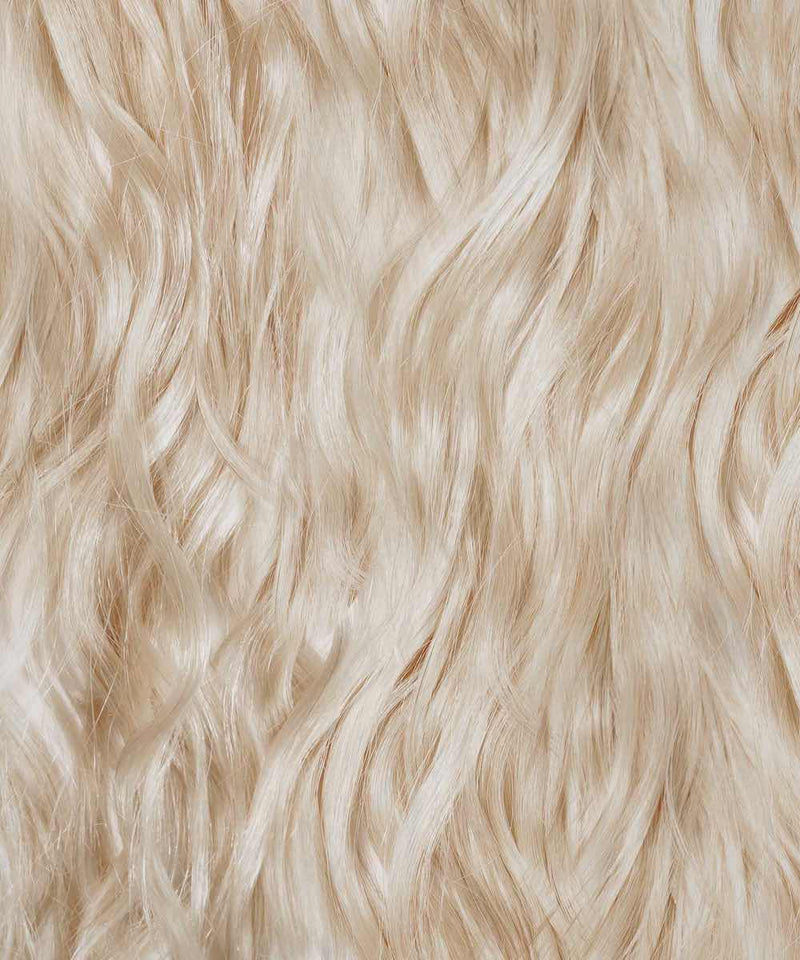 Close-up of Perfect Locks Wavy Fusion I-Tip Hair in ice blonde, featuring long, wavy Remy extensions with a soft texture.