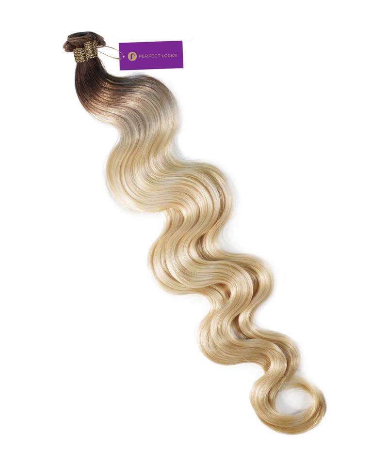 A bundle of Perfect Locks Wavy Hybrid Weft Hair Extensions in Chestnut Brown Balayage transitions from dark to light, secured with a purple tag.