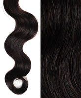 A close-up shows Perfect Locks Wavy Invisi Tape In Hair Extensions in Highlighted Brown Auburn, spiral curl left, smooth hair right.#color_natural-black-(1B)