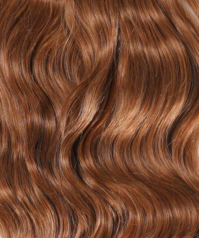 Close-up of long, wavy, shiny honey blonde hair with Perfect Locks Wavy Clip-In Ponytail Extensions (Color: 27), smooth and vibrant.